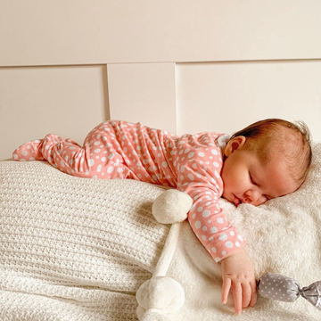 Little baby girl sleeping in LiaaBébé Light Pink Sleepsuit.