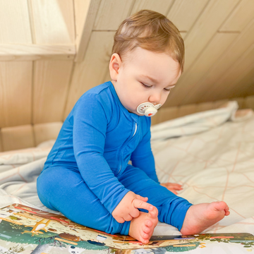 Baby boy playing in LiaaBébé Sleepsuit in french blue color.