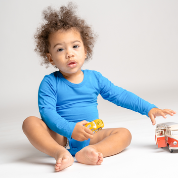 Little boy playing and wearing LiaaBébé Bodysuit in french blue color.