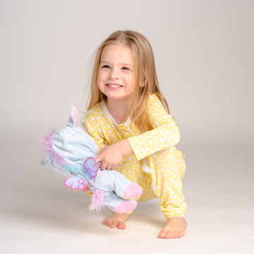 Smiling little girl wearing LiaaBébé Light Yellow Sleepsuit while playing.